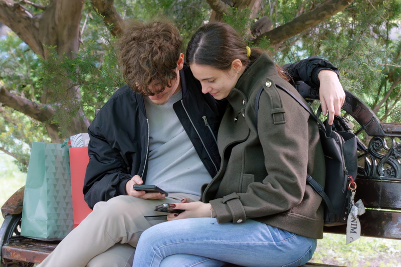 Boy and girl watching together smartphones